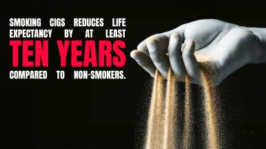 Black poster with large white and red text reading, "Smoking cigs reduces life expectancy by at least ten years compared to non-smokers." On the right, a pale hand lets sand pour through its fingers like an hourglass.